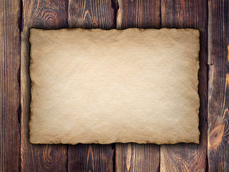Old handmade paper sheet on wooden backgroundの写真素材