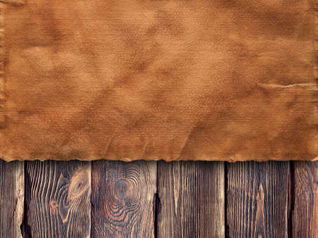 Old creased paper sheet on wooden wall backgroundの写真素材