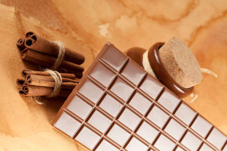 Homemade candy - chocolate, cocoa and cinnamon sticks on paper background