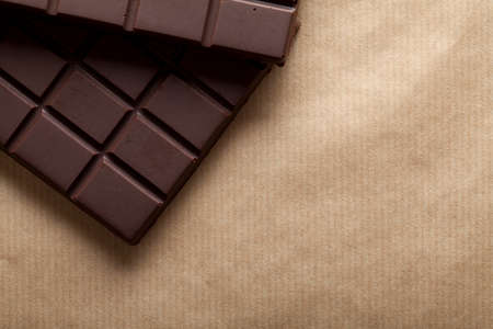 Dark chocolate bar on brown paper backgroundの写真素材