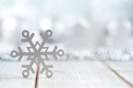 Snowflake on wooden and silver background
