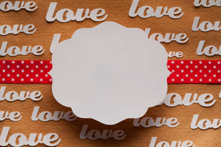 Blank label and red ribbon on paper background