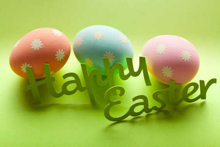 Happy Easter - three eggs and inscription on green backgroundの写真素材