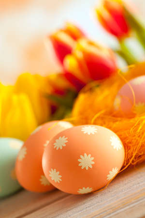 Painted Easter eggs and colorful spring flowersの写真素材