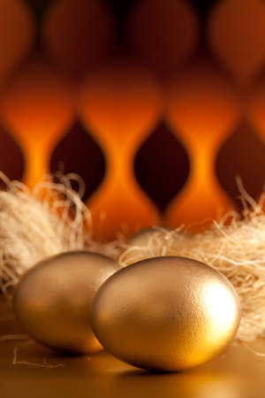 Golden eggs on abstract patterned backgroundの写真素材