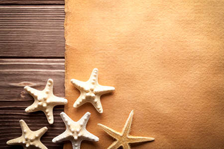 Starfishes and blank handmade paper sheet on wooden tableの写真素材