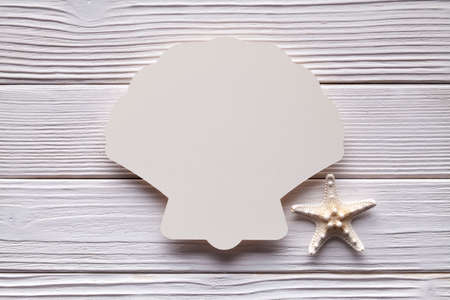 Paper label in shape of shell on wooden backgroundの写真素材