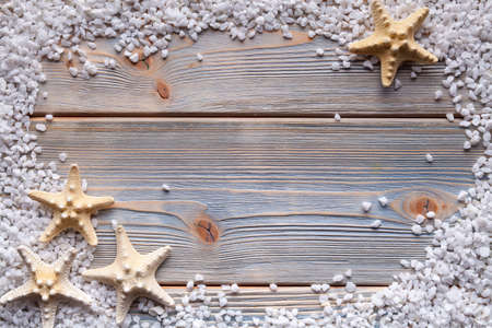 Starfish and stones on wooden backgroundの写真素材