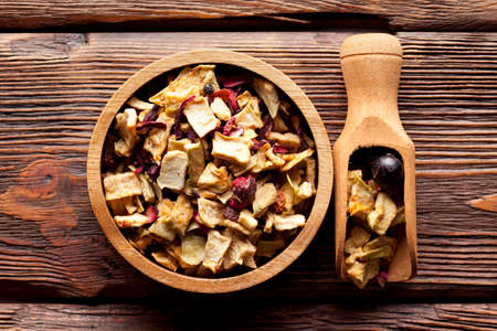 Dried fruit tea mix in a bowl and wooden scoopの写真素材
