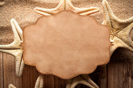 Paper label and starfish on wooden planks and sandの写真素材