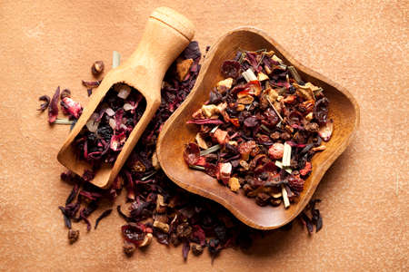 Mix of dried tea leaves in bowl and scoop on paper backgroundの写真素材