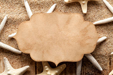 Paper card and starfishes on sandの写真素材