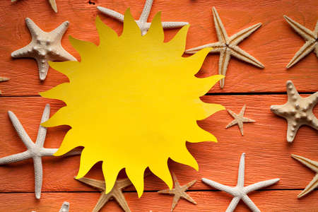 Paper sheet in the shape of the sun and shellsの写真素材