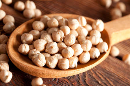 Chickpeas in spoon on wooden tableの写真素材
