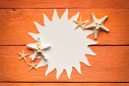 Paper sheet in the shape of the sun on wooden backgroundの写真素材