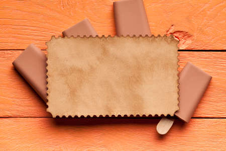 Ice lollies and blank paper sheet on wooden backgroundの写真素材