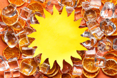 Shape of sun cut out of paper and ice cubes