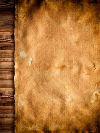 Old stained paper sheet on wooden backgroundの写真素材