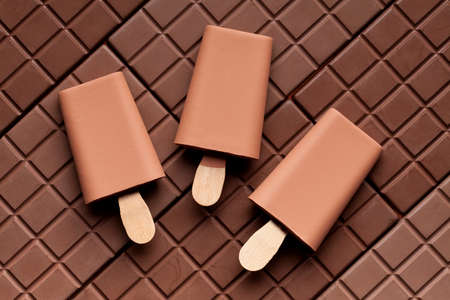 Ice cream - ice lollies on chocolate background