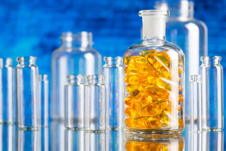Fish oil capsules in glass containerの写真素材