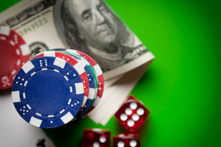 Poker chips, dices and playing cards on green table