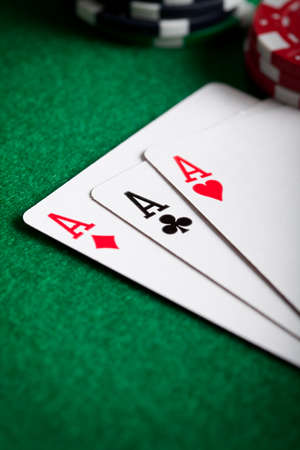 Playing cards and poker chips on green tableの写真素材