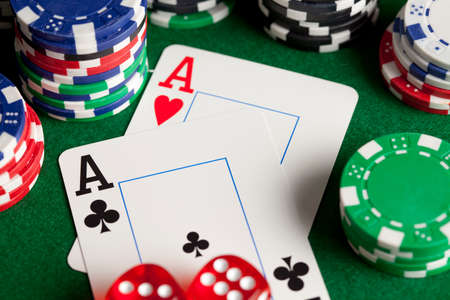 Playing cards, poker chips, and dices on green table