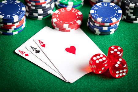 Playing cards, poker chips, and dices on green tableの写真素材