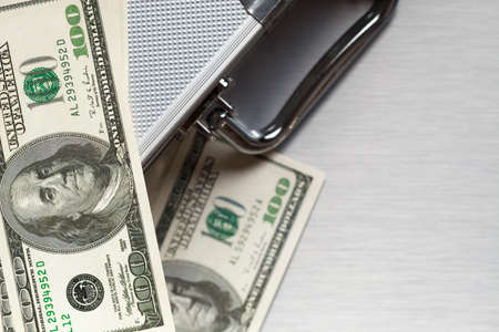 Metallic business suitcase and dollar billsの写真素材