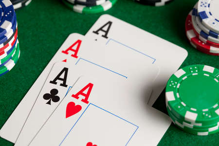 Playing cards and poker chips on green tableの写真素材