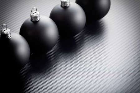 Black christmas baubles on carbon backgroundの写真素材