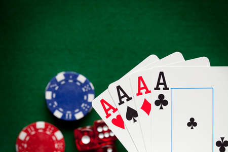 Playing cards, poker chips, and dices on green tableの写真素材