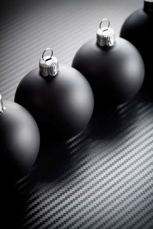 Black christmas baubles on carbon backgroundの写真素材