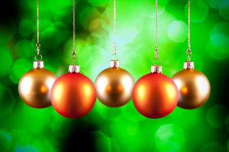 Red and gold baubles on green backgroundの写真素材