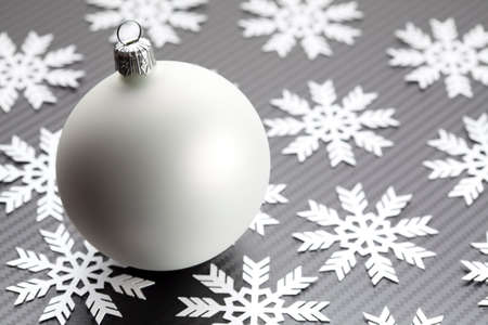 White christmas bauble and snowflakes on black backgroundの写真素材