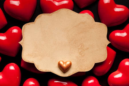 Blank paper label and red hearts on black backgroundの写真素材