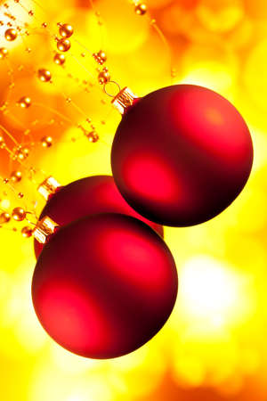 Red Christmas baubles on yellow backgroundの写真素材