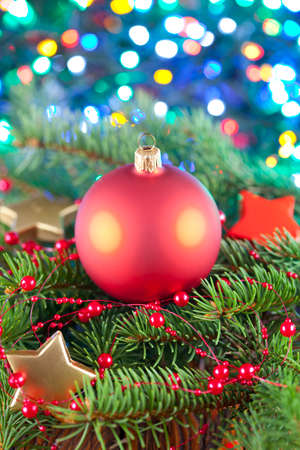 Christmas ball on spruce branch and lighting backgroundの写真素材