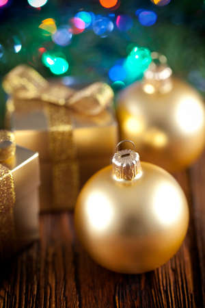 Gold Christmas baubles and gift boxes on wooden backgroundの写真素材
