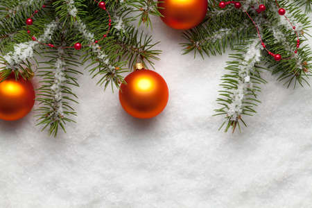 Spruce branches and Christmas balls on snow backgroundの写真素材