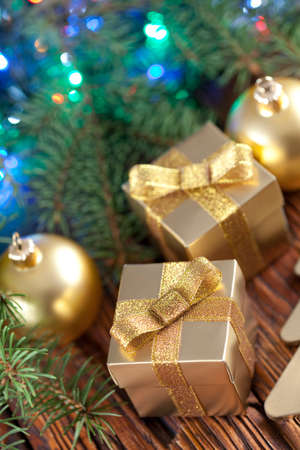 Christmas baubles, gift boxes and spruce branch on wooden backgroundの写真素材