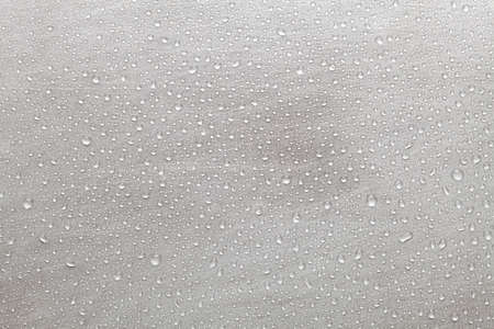 Scratched metal surface covered with water dropletsの写真素材