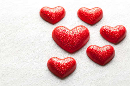 Red hearts covered with drops of water on scratched backgroundの写真素材