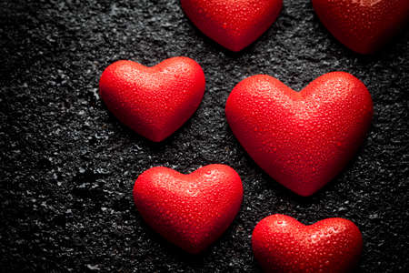 Red hearts covered with drops of water on a black backgroundの写真素材