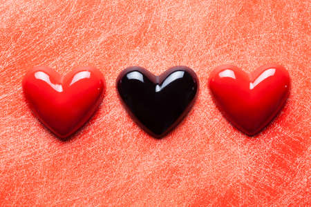 Two red and one black heart on scratched surfaceの写真素材