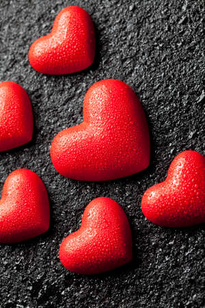 Red hearts with water droplets on black backgroundの写真素材