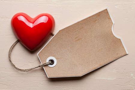 Red heart and tag on plastered backgroundの写真素材