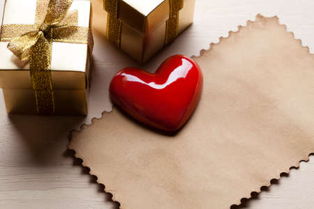 Red heart and two gold gift boxes and paper cardの写真素材