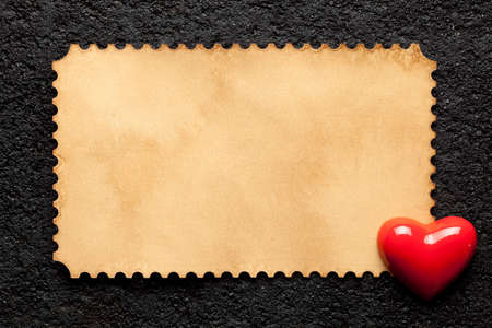 Blank paper sheet and figure in the shape of a heart on a black backgroundの写真素材