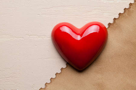 Red heart and paper sheet on plaster backgroundの写真素材